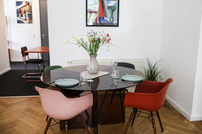 Dining table set with wild flowers, glasses and plates in the living room of the holiday apartment