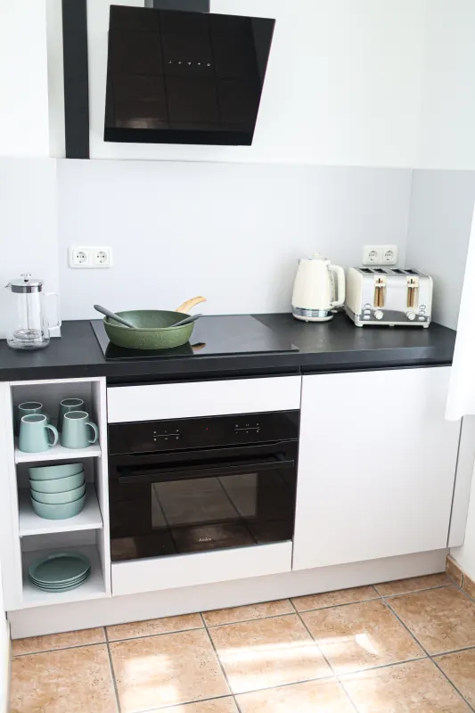 Kitchen unit with induction hob, oven, extractor hood, kettle and toaster